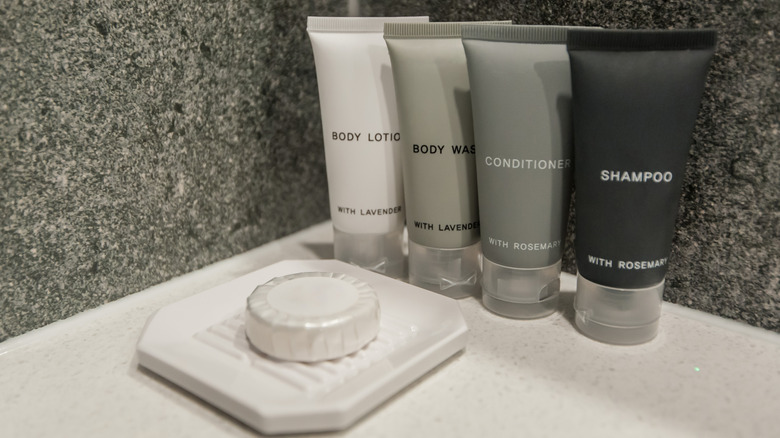 Bottled toiletries and a bar of soap in a hotel