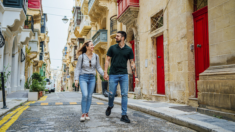 Young cheerful couple enjoying a walk together in Valletta, Malta