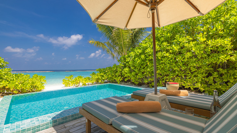 Reclining chairs facing resort pool and beach