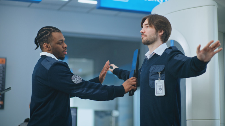 Man being searched by TSA agent in an airport