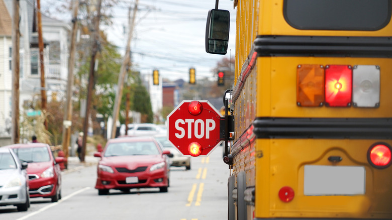 School bus with stop sign arm extended in traffic