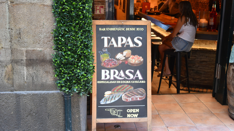 a blackboard displaying the types of small bites available at a tapas bar