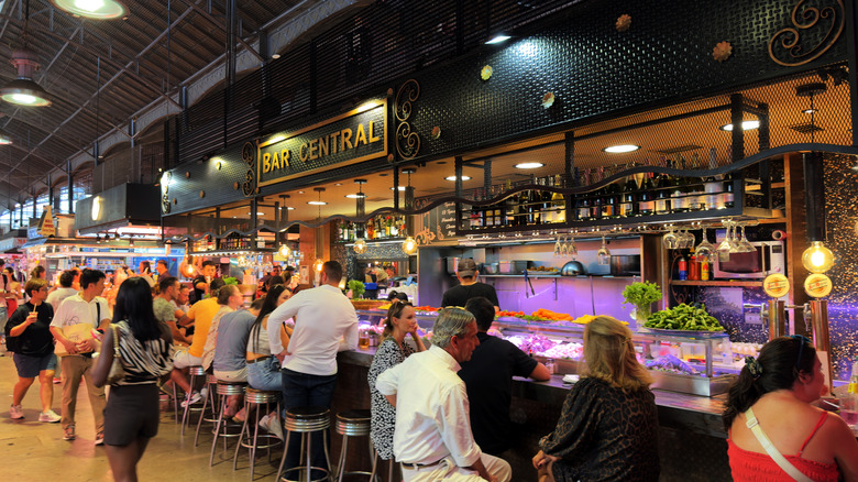 people sitting on barstools and enjoying tapas at a local bar in Spain