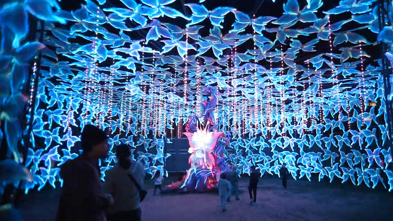 People walking through a light-up butterfly installantion from Tianyu Arts and Culture