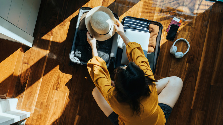 An overhead shot of a woman packing her suitcase