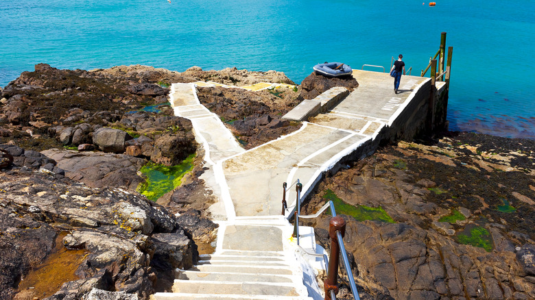 Landing stage for the ferry on Herm island leading to bright blue waters