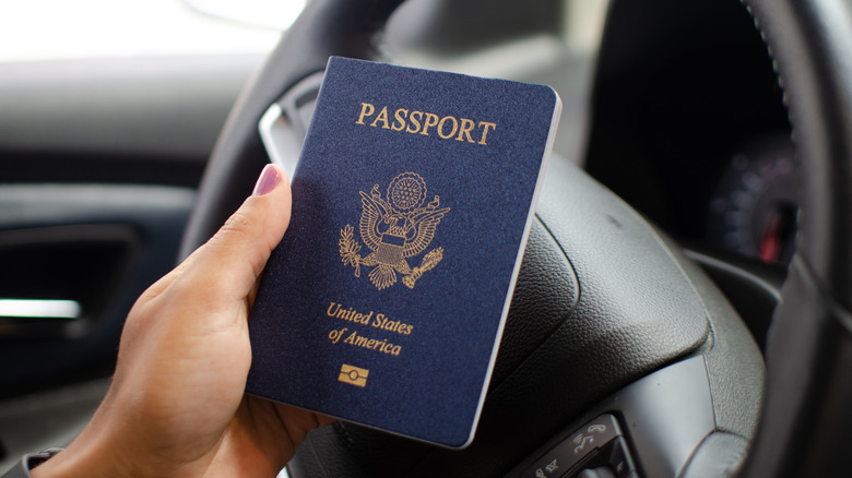 Close up of a US passport held against a steering wheel