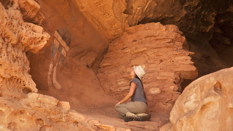 Woman hiker in front of ancient rock painting in Canyonlands National Park