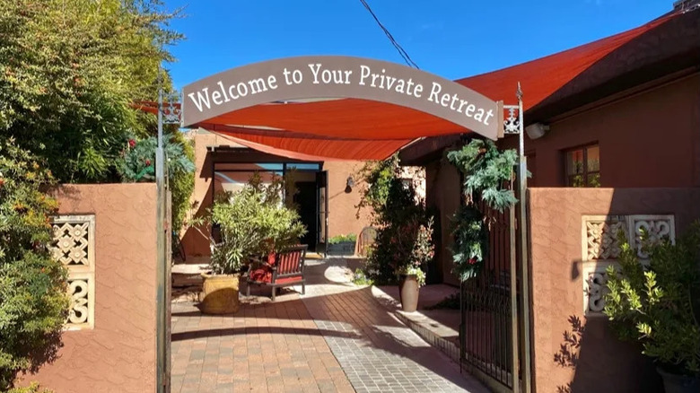 Outdoor seating area and sign that says "welcome to your private retreat" at New Day Spa