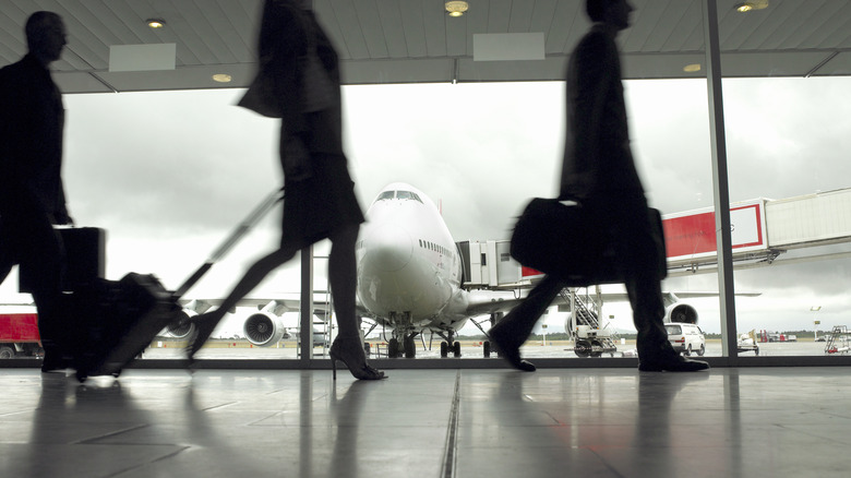 People walking through an airport corridor