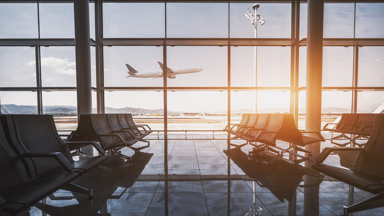 Plane taking off through airport gate window