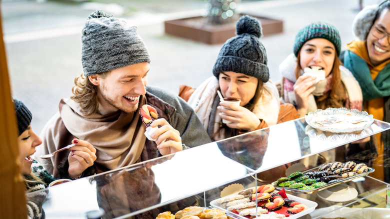 A group of friends eating from a food cart