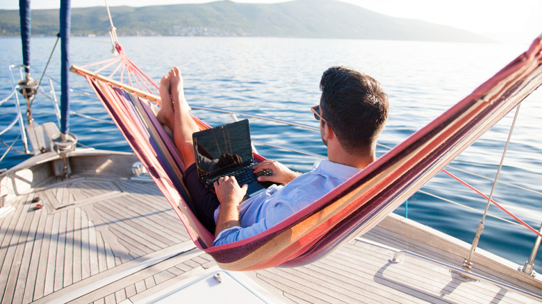 Man working on a laptop while on a boat in the water