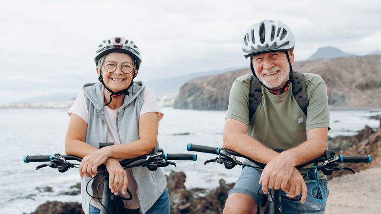 An older adult couple enjoys a scenic bike ride.
