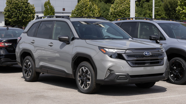 A gray Subaru Forester waits parked in the lot of a dealership