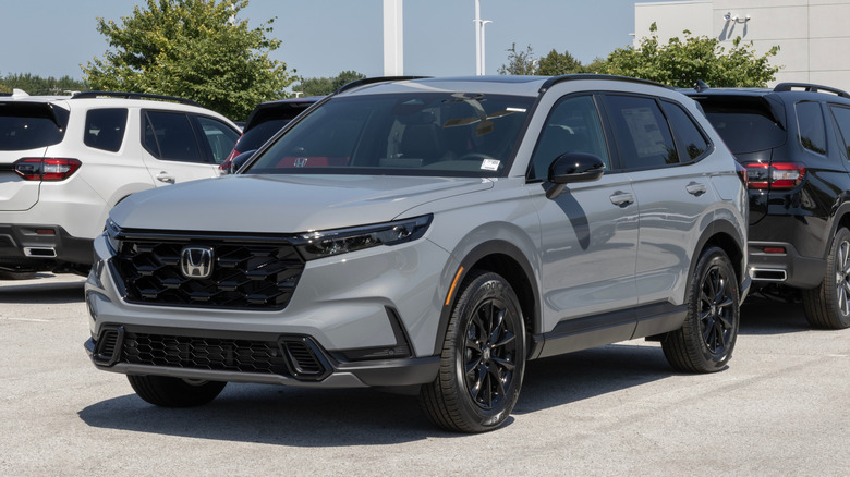 A gray Honda CR-V parked in the lot of a dealership