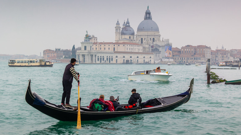 Tourists aboard a gondola in Venice, Italy, in winter