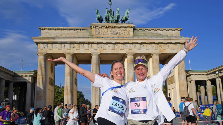 Two marathon winners celebrate in front of the Brandenburg Gate