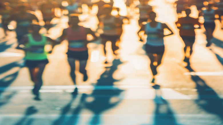 A crowd of runners blurred in motion during a marathon,