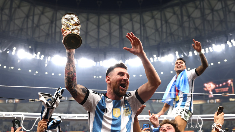 Lionel Messi celebrates with the World Cup trophy in 2022