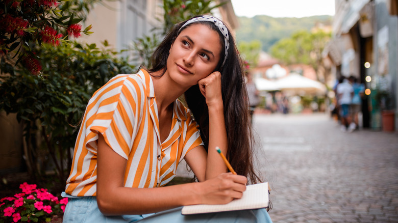 A woman journaling while traveling