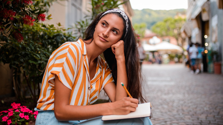 A woman journaling while traveling