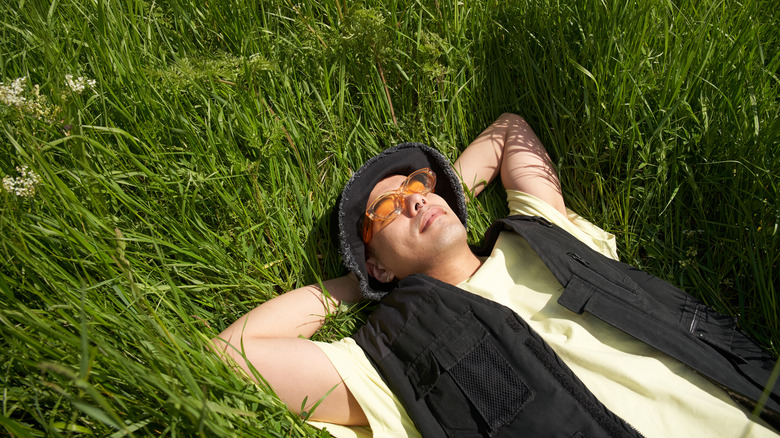 Fashionable man relaxing in long grass