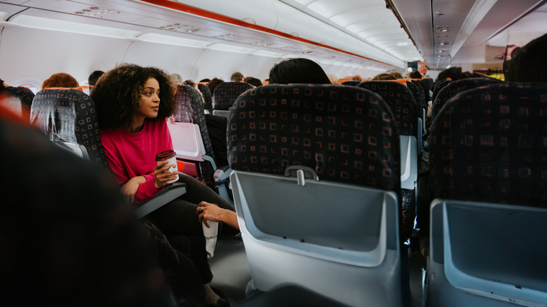 A woman sitting in the economy section of a plane