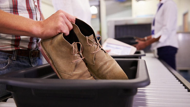 Boots being placed in screening trays at airport security