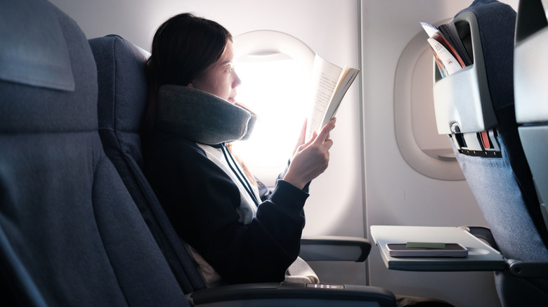 Airplane traveler reading a book