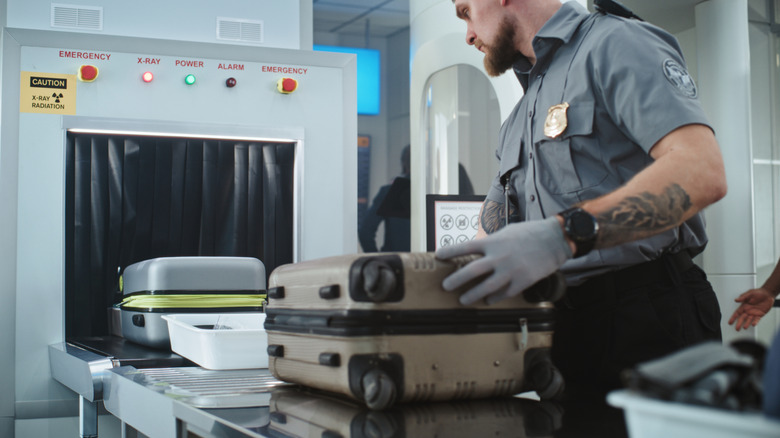 TSA worker handling luggage