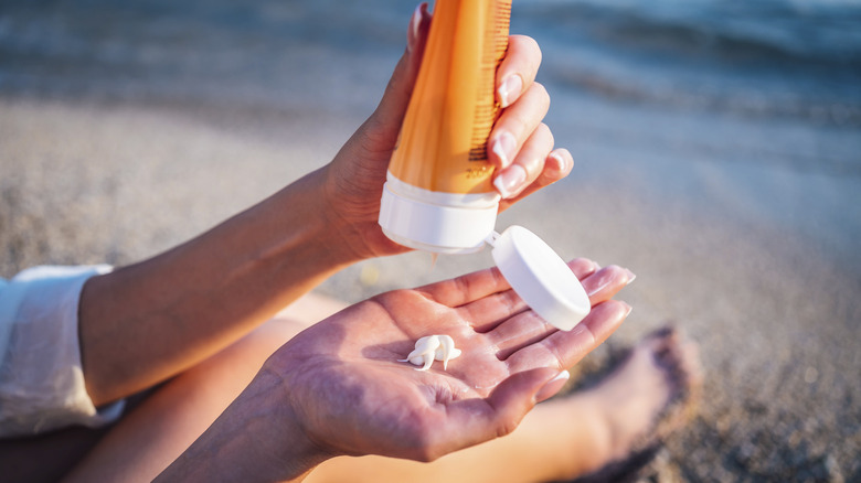 person putting sunscreen on hand