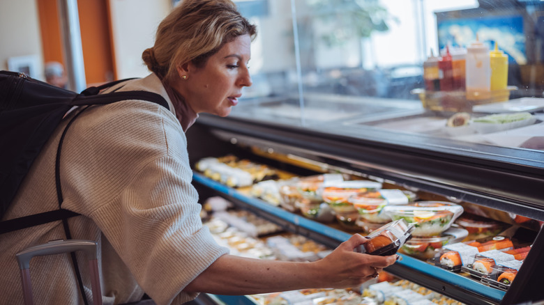 Woman buying sushi at the airport