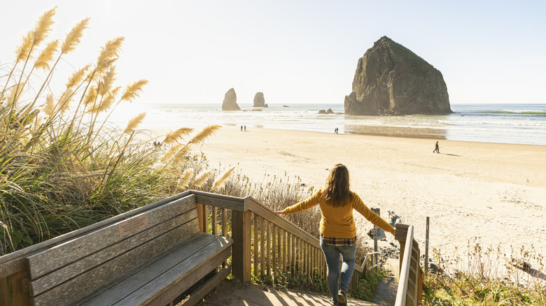 Woman walking down a stairway to Cannon Beach