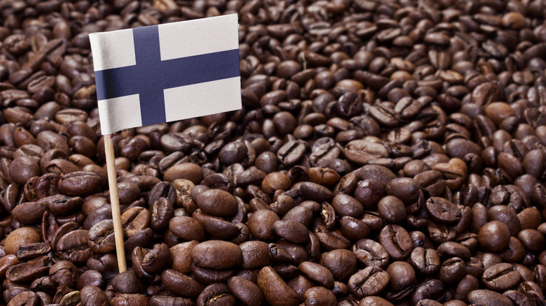 A tiny flag of Finland sticking up in a spread of coffee beans