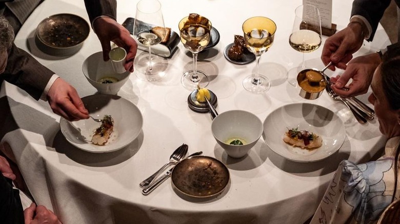Plated food being presented at a table at Zilte, Antwerp's only three star Michelin restaurant