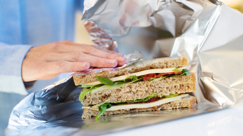 Person wrapping sandwich in foil