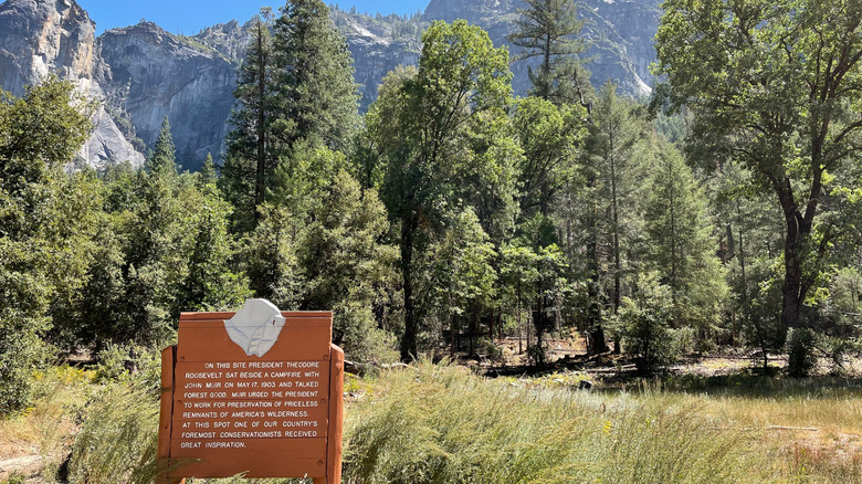 A historical sign at Yosemite National Park with mountains in the background