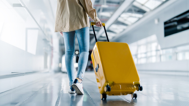Woman pulling luggage in an airport