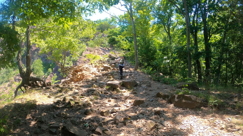 woman walks up steep rock scramble