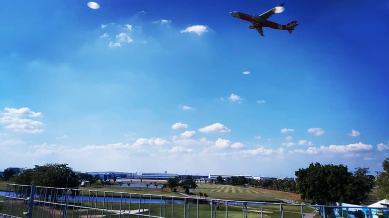 An airplane flying over Kantarat Golf Course