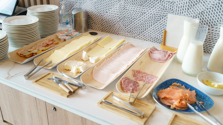 Breakfast buffet with cheese, cold cuts, and milk