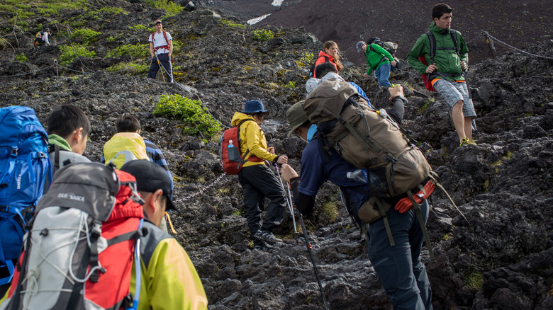 Hikers loaded with equipment climbing Mt. Fuji