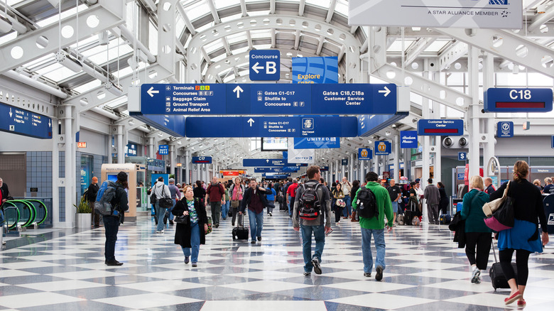 Travelers walking through a terminal at O'Hare International Airport in Chicago