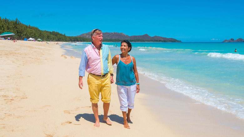 Retired couple strolling the beach in Hawaii