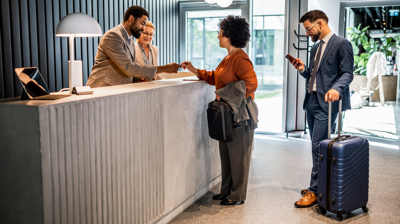Woman checking into hotel with receptionist