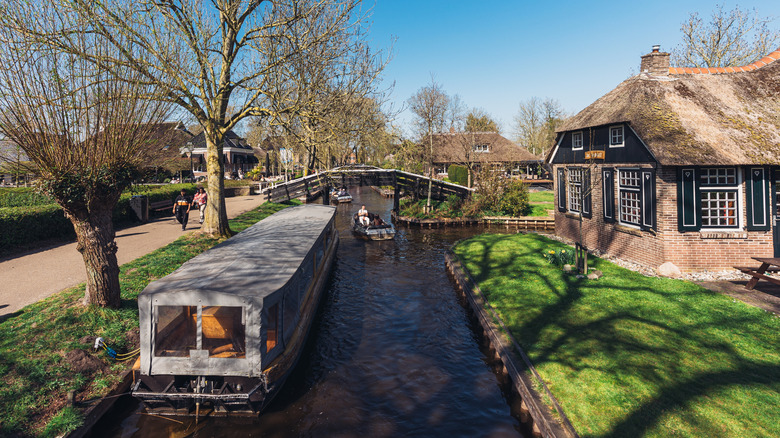 Boats on a canal next to a walkway in Giethoorn