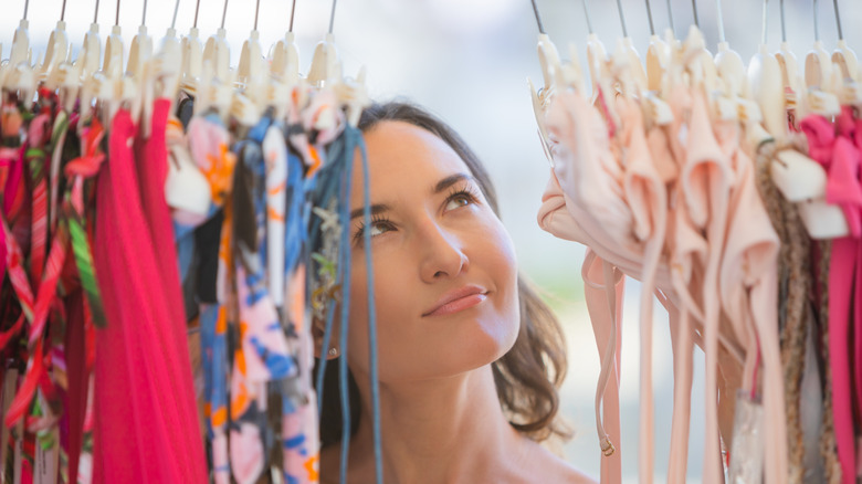 A woman looks as two-piece swimsuits on a rack