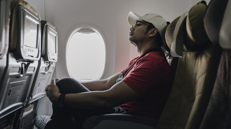 Man sitting in a window seat on a plane