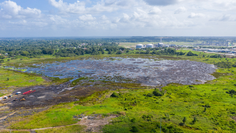 Aerial view of Pitch Lake, a black tar lake surrounded by green fields